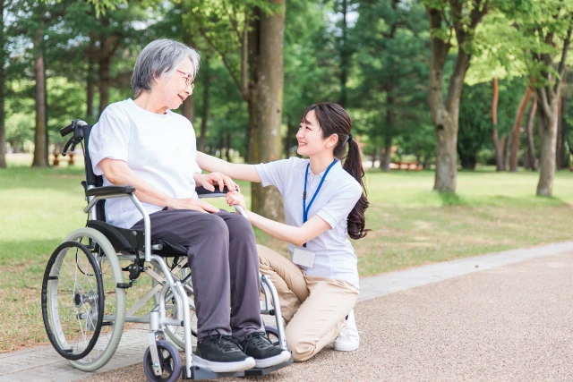 車椅子に乗った高齢者とスタッフ