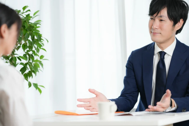 人と対面して説明するスタッフ