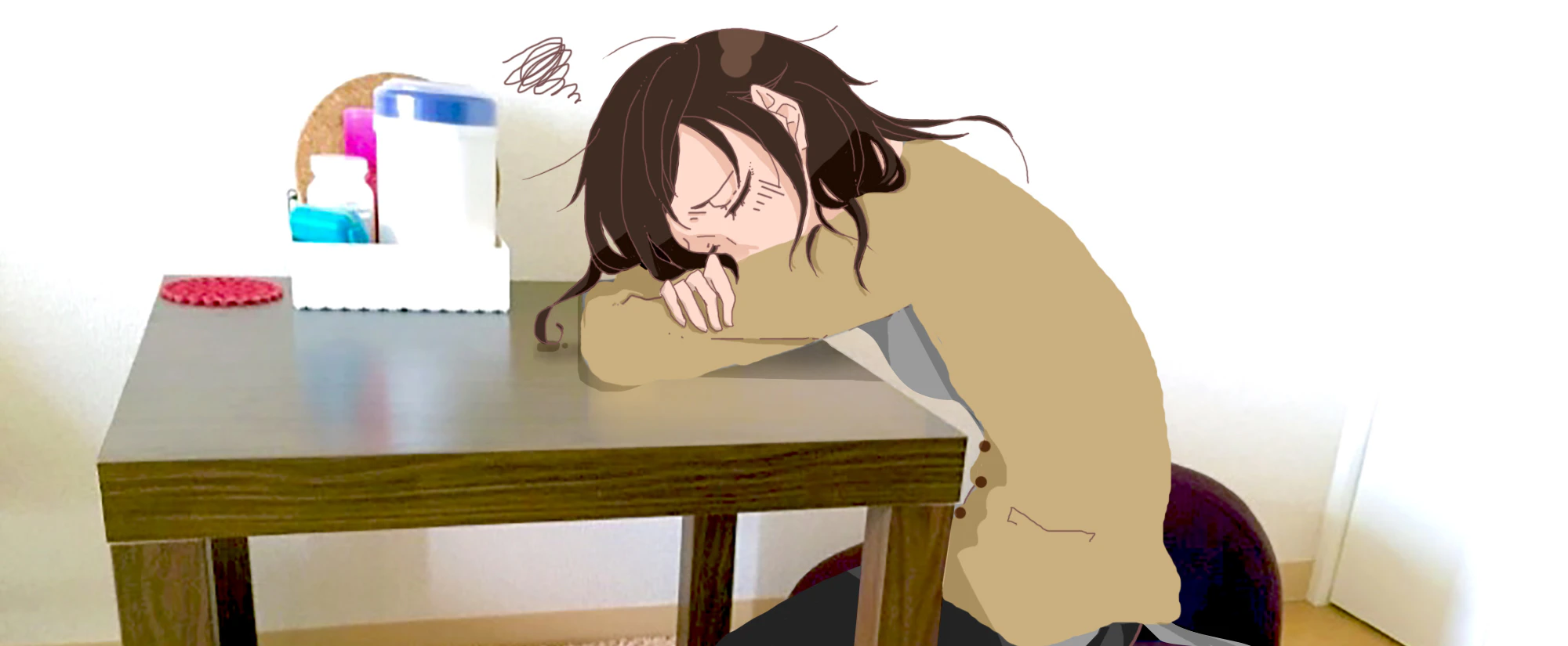 机に突っ伏して考え込んでいる看護師