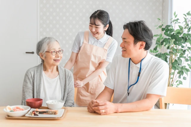 食事をする女性とスタッフ