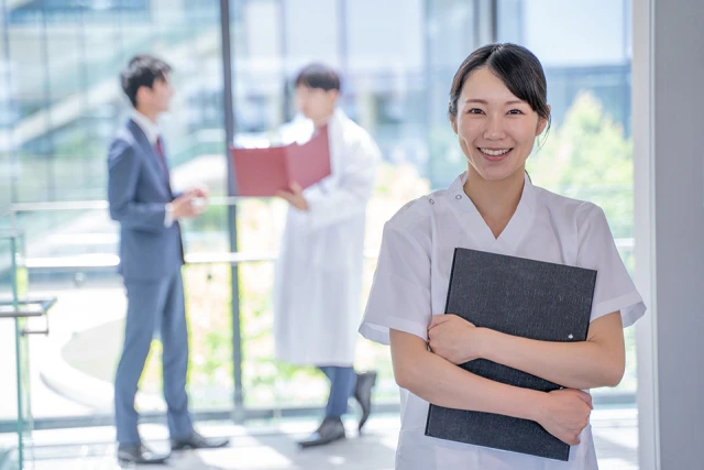 ファイルを持って笑顔で微笑む看護師