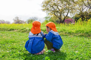 外で座り込む2人の園児
