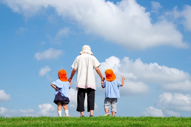 青空の下の保育士と2人の園児