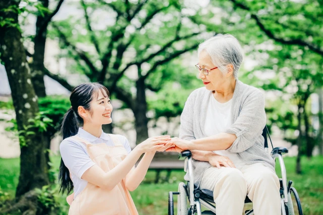 車椅子の高齢女性とスタッフ