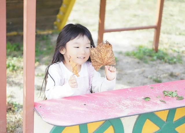 落ち葉で遊ぶ女の子