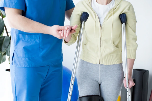 松葉杖の患者を支える看護師