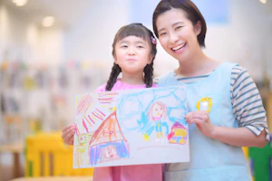 お絵かきを手に笑顔の保育士