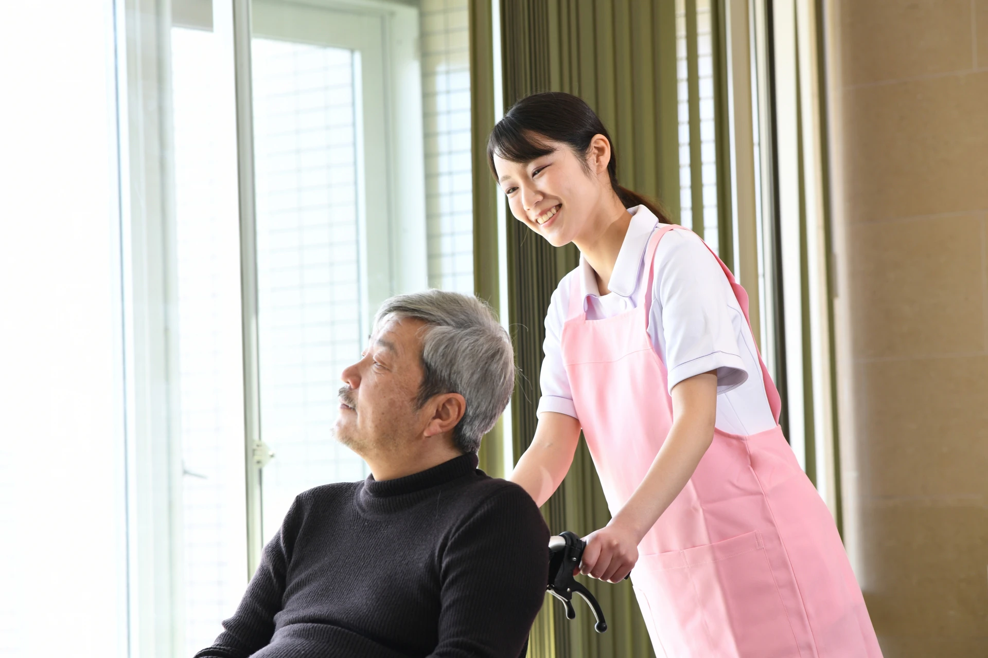 車いすの男性と看護師さん