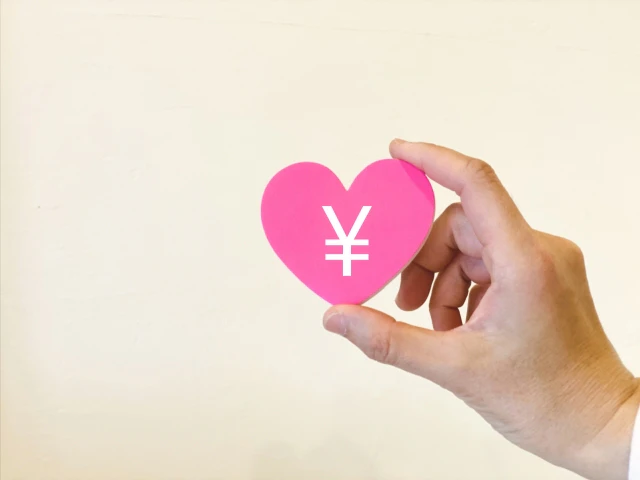 ￥の書かれたハートを持つ手