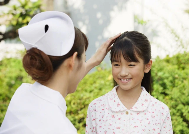 子どもの頭をなでている看護師