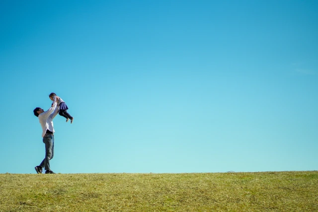 男性が子供を抱き上げる姿