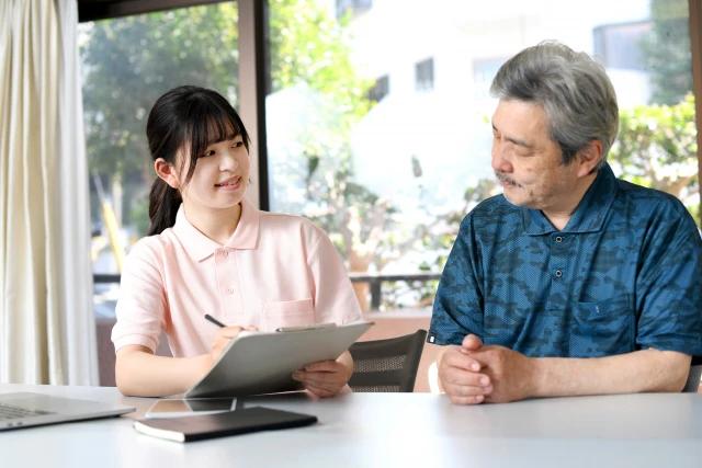 聞き取り調査をする男性とスタッフ
