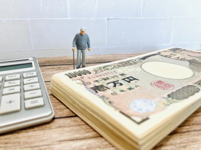 一万円束と電卓、おじいさんのミニチュア人形