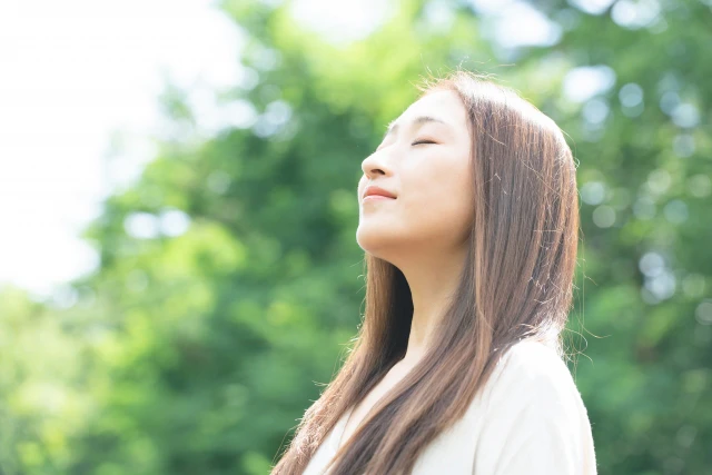 緑の中で息を吸う女性