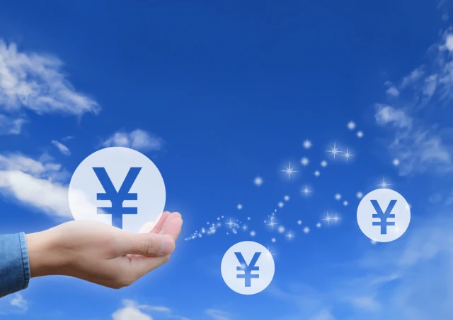 ￥マークを持った手　青空