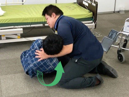 利用者さんの上体を引くように起こす
