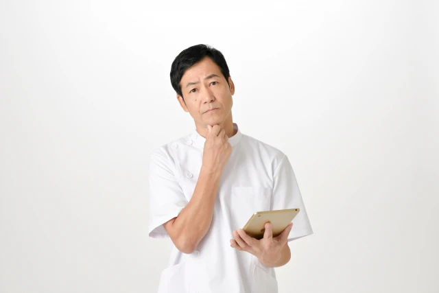 電子パッド片手に悩む男性スタッフ