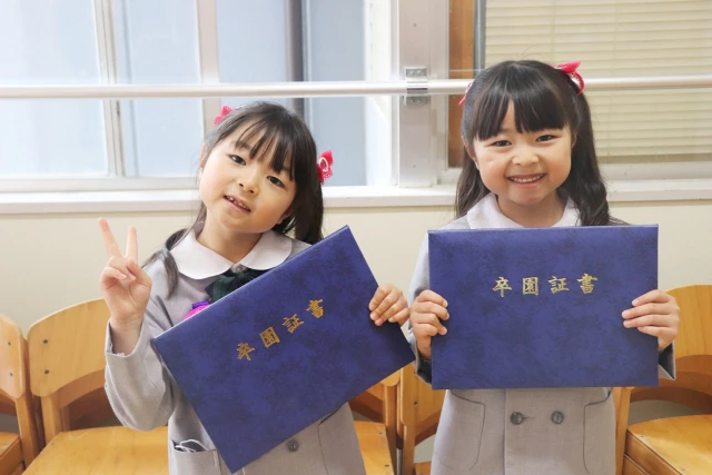 卒園証書を持った2人の女児
