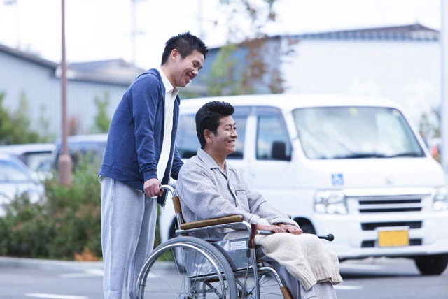 車いすを押す男性