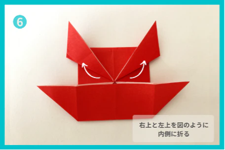 ⑥右上と左上を、それぞれ持ち上げて斜め上方向に折る。