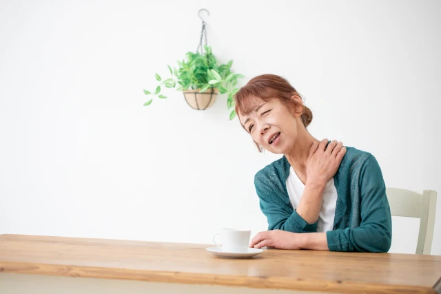 肩に手を当てる女性