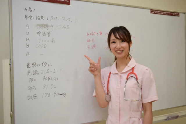 ホワイトボードを指す看護師さん
