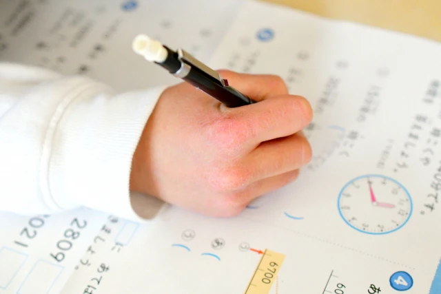 シャープペンを持って問題を解く子供の手