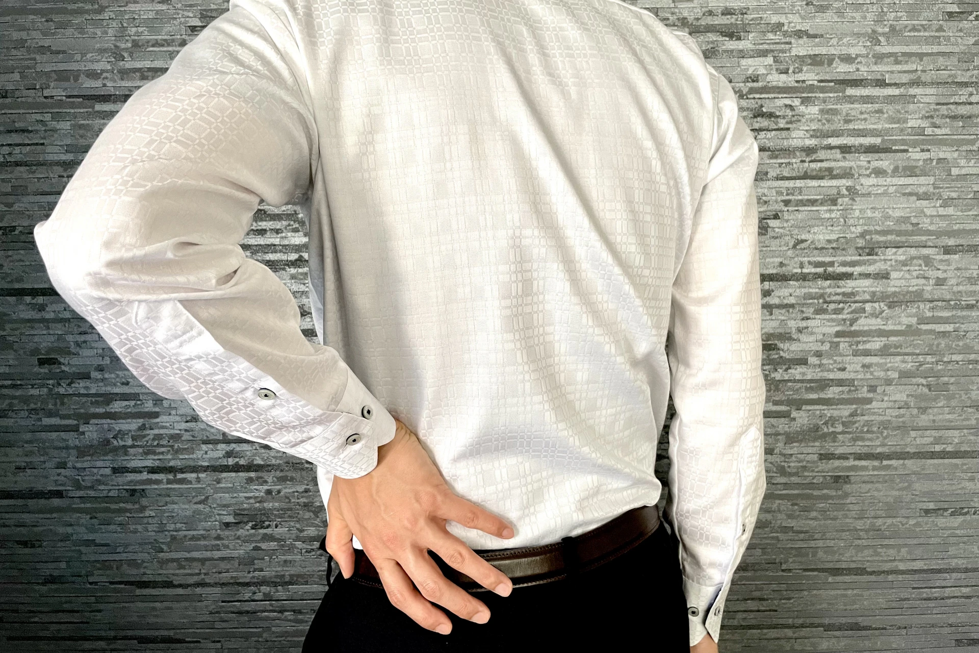 腰に手を当てる後姿の男性