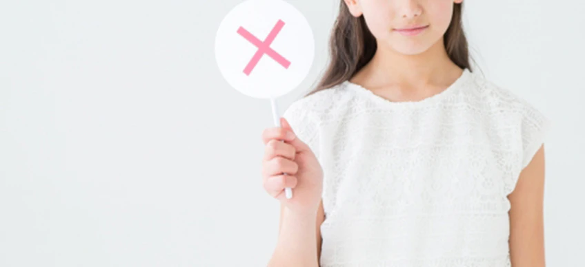 女の子がバツ印を出している