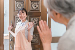 手を振るスタッフと年配の方