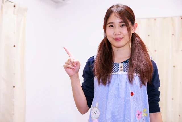 指をさす保育士