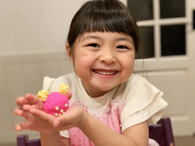 粘土細工を持って笑う女の子