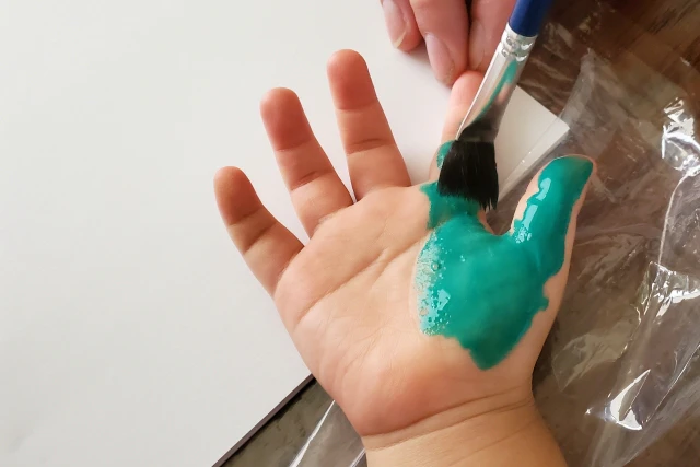 絵の具を塗っている子供の手