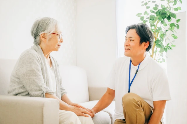 向き合う高齢女性とスタッフ