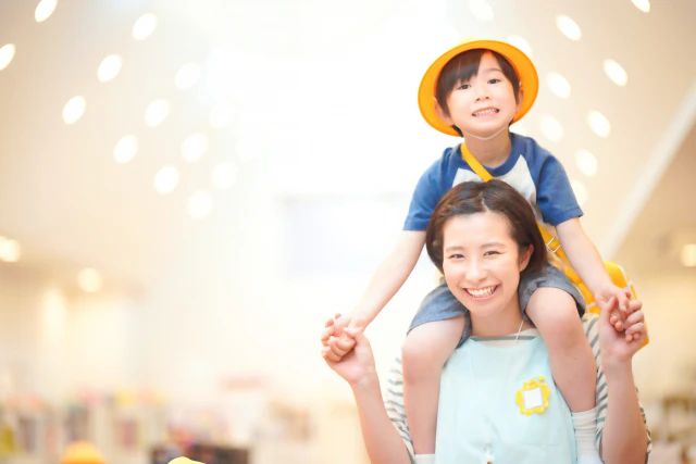 肩車をする保育士さんと子供