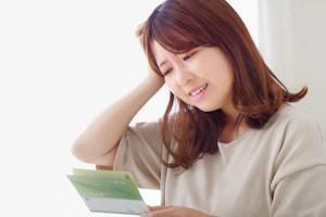 給料が安すぎて通帳を見て頭を抱える女性の介護職