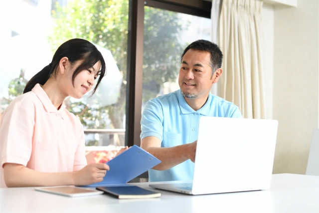 パソコンを見ながら話すスタッフ