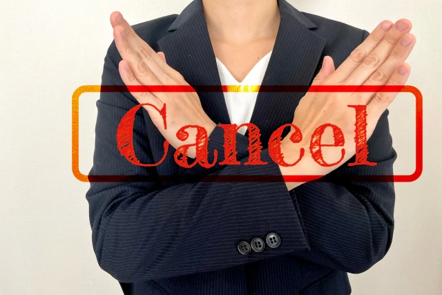 腕を交差させて×を表現する人