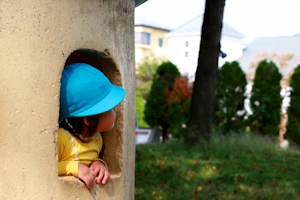 遊具から顔を出す園児