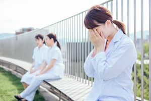 手で顔を覆うスタッフ