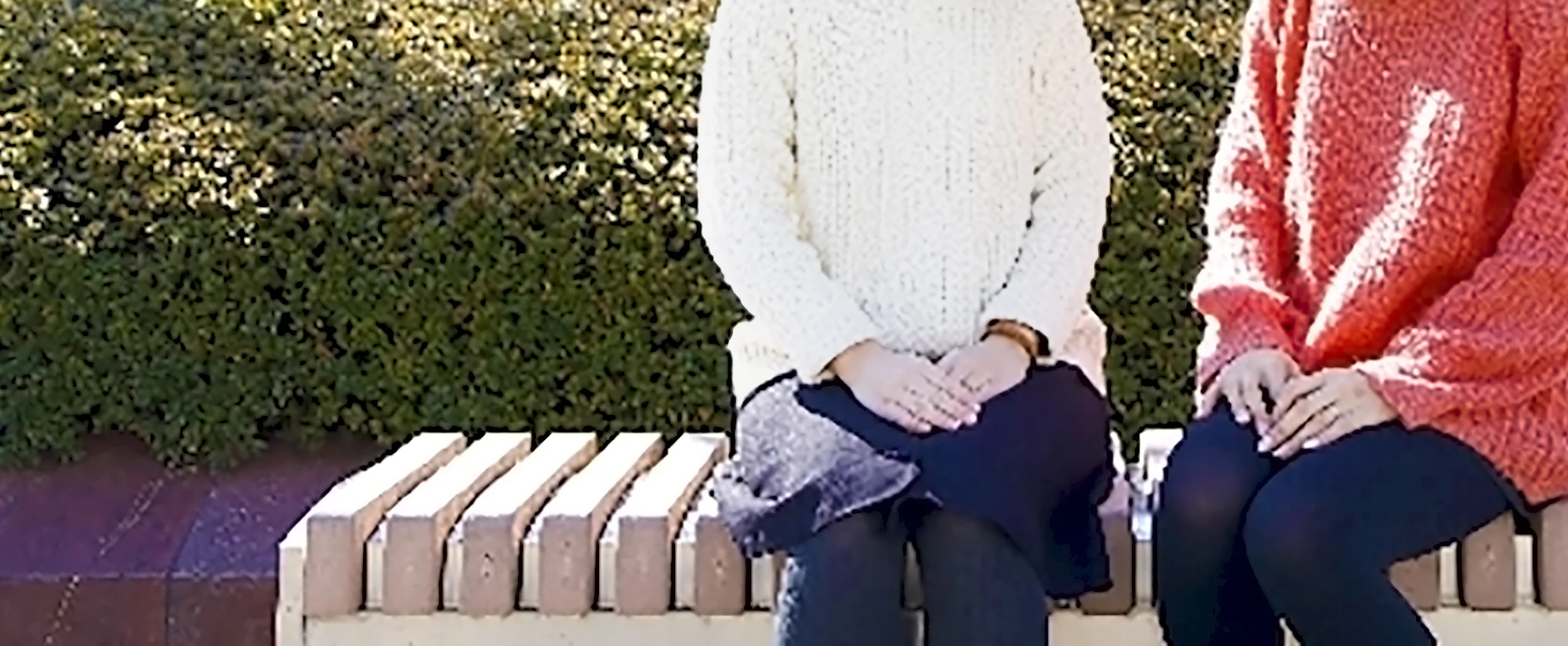 ベンチに腰掛けて話す女性2人