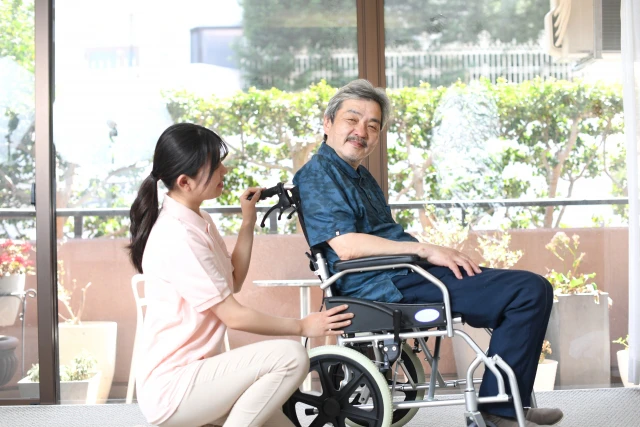 車椅子の高齢者とスタッフ