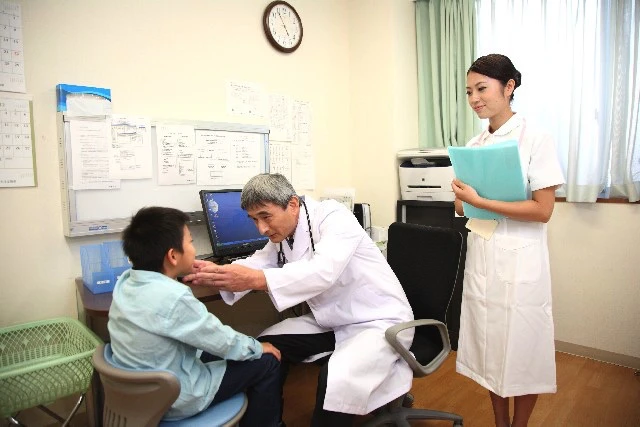 子どもの診察をしている医師と看護師