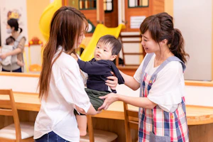 保育士に子どもを預ける母親