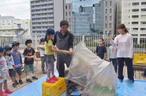脱穀体験をする子ども