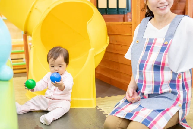 ボール遊びする赤ちゃんと保育士さん