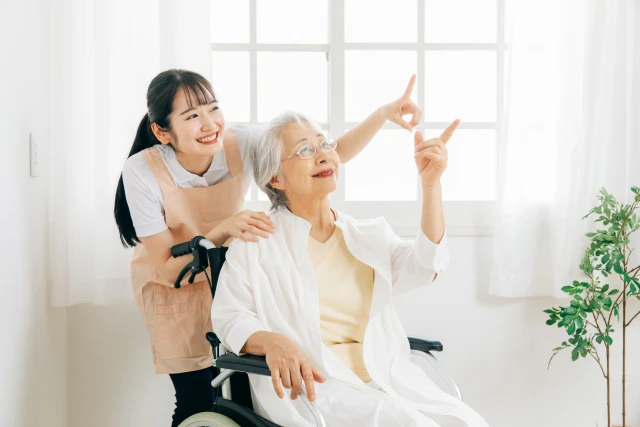 スタッフと車椅子の高齢女性が天井に指差し