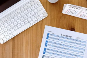 給与支給明細書とキーボードと卓上カレンダー