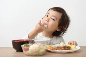 上手にスプーンで食事をする女の子