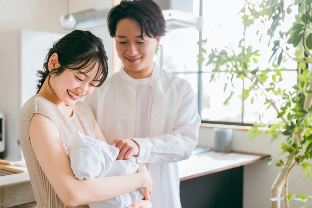 赤ちゃんを抱く笑顔の母と夫